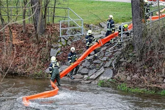 Unbekannte Substanz im Wasser: Flüsse Chemnitz und Würschnitz stark verunreinigt - Kameraden der Feuerwehr bauten eine Ölsperre auf, um die weitere Verunreinigung der Chemnitz zu stoppen.