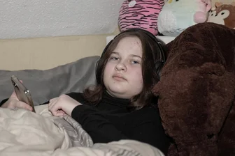 Unendlich müde: Wie eine Mutter im Landkreis Zwickau um das Leben ihrer Tochter kämpft - Oft nutzt Emilie Kopfhörer, um sich von den Umgebungsgeräuschen abzuschotten. Per Handy hält sie Kontakt zu einer Freundin – das schafft sie aber nur für wenige Minuten am Tag. Dann ist sie zu erschöpft für alles andere.