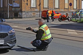 Unfall auf Werdauer Straße in Zwickau: 47-jähriger Motorradfahrer wird schwer verletzt - Ein Polizist nimmt ein beteiligtes Auto unter die Lupe.