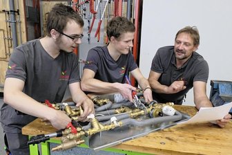 Unternehmen setzt auf Azubi-Offensive - Max Langhammer (l.) und Cedric Csulits lassen sich von Lehrausbilder Ronny Kultscher in der Praxiswerkstatt der Firma Seidel in Lengenfeld die Funktion einer Station für die Trinkwassererwärmung erklären.