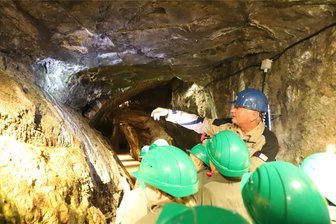 Unterricht im Silberbergwerk: Was ein „Klassenzimmer“ in Freiberg so besonders macht - Grubenführer Stefan Thiem zeigt den Kindern Besonderheiten des Gesteins unter Tage im Silberbergwerk Freiberg.
