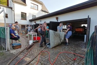 Unwetter flutet Heinsdorfer Grundstück gleich zweimal - Maritta Schürer (links sitzend) war irgendwann am Ende ihrer Kräfte. Zweimal innerhalb von zwei Tagen war sie mit ihrer Familie vom Unwetter betroffen. Zum Glück packten viele Helfer mit an.