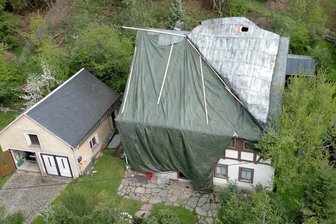 Unwetter im Erzgebirge: Windböe reißt Hausdach auf - Bäume fallen in Freileitungen - Eine starke Windböe schlug das Blechdach auf einem Wohnhaus in Steinbach nach oben. Die Feuerwehr sicherte das Dach notdürftig mit Planen ab.