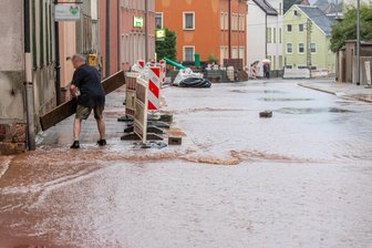Unwetter mit Starkregen im Erzgebirge – Anwohner stemmen sich gegen Wassermassen - Ein Anwohner in Hohndorf versuchte, sich mit Brettern selbst zu helfen.