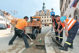 Unwetter setzt Penig unter Wasser - Peter Vasold, Mitarbeiter beim Peniger Bauhof, und die Feuerwehrleute Kevin Kirsch und Udo Lange (v.l.) haben am Mittwochnachmittag verstopfte Gullys gereinigt, damit Regenwasser wieder abfließen kann.