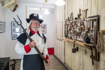 US-Amerikaner läuft bei Bergparade mit: Zwei Kalifornier finden im Erzgebirge ihr neues Zuhause - Terry Fairhurst mit einer Uniform eines Freiberger Hüttenmanns mit einer Hüttengabel, mit denen früher die Bleibarren transportiert wurden.