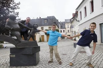 Vater und Sohn sollen Einkaufsstraße beleben - Peter Ohser, Enkel von Erich Ohser mit seinen Söhnen v.re.: Owen und Graham an der Vater-und-Sohn Skulptur vor der e.o.plauen Galerie an der Nobelstr.