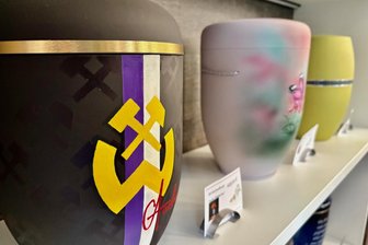 Veilchen-Wappen auf der Urne: Wie sich das Bestattungswesen im Erzgebirge wandelt - Blickfang im Schauregal des Bestattungshauses in Lauter: die Wismut-Urne.