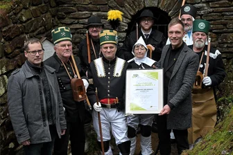 Verein im Erzgebirge macht Altbergbau im Kuttengrund erlebbar und bekommt dafür Auszeichnung - Bei der Übergabe der Auszeichnung: vorn links der Lößnitzer Bürgermeister Alexander Troll, Vereinschef Jens Hahn (Mitte) und Erik Gläser von der Fachstelle Ehrenamt beim Landratsamt Erzgebirgskreis (re.) mit Vereinsmitgliedern.