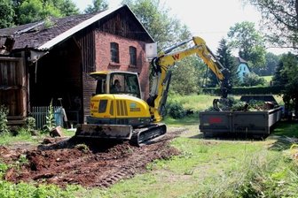 Vereinsmitglieder entrümpeln und sortieren Dachbodenfunde - Die Reste von einem zusammengestürzten Gebäude schaffte der Bagger beiseite. 