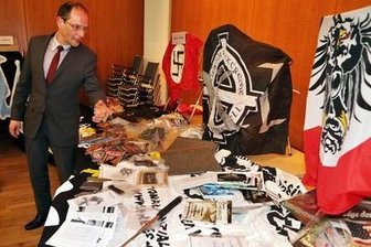 Vereinsvermögen der Nationalen Sozialisten Chemnitz wird verwertet - Der damalige Innenminister Markus Ulbig (CDU) betrachtete 2014 Beweissstücke, die bei Hausdurchsuchungen in Wohnungen von Vereinsmitgliedern des NSC im März gesammelt worden waren.
