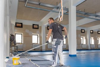Vereinszentrum an der Auerbacher Beegerstraße: Einzug auf 2022 verschoben - Kevin Weinhold von der Maler GmbH Reichenbach streicht eine Wand im 2. Obergeschoss des künftigen Soziokulturellen Zentrums Auerbach. Der Fußboden auf der Etage, die der Billardverein bezieht, ist bereits fertig. Laut Stadtverwaltung soll die umgebaute Textilfabrik an der Beegerstraße im Frühjahr 2022 bezugsfertig sein