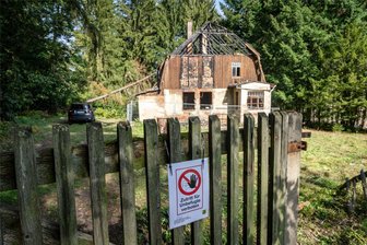 Verheerender Hausbrand in Auerswalde: Feuerwehr steht gleich vor mehreren Problemen - Das Gebäude wurde inzwischen mit einem Bauzaun gesichert. Schilder weisen auf ein Betretungsverbot wegen Einsturzgefahr hin. Am Montag war die Feuerwehr noch vor Ort, um bei möglichen Glutnestern reagieren zu können.