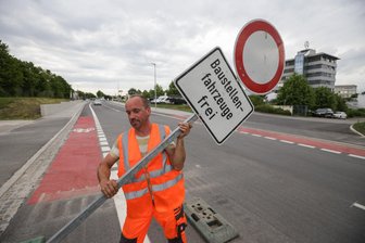 Verkehr auf neuem Abschnitt der Fraunhoferstraße rollt - Aufatmen an der Fraunhoferstraße: Daniel Rößner entfernt die Sperrschilder, hier am Kreisverkehr Werner-Seelenbinder-Straße.