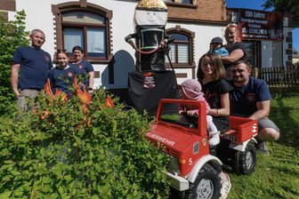 Verrückte Idee im Erzgebirge: Warum in einem Gartenstrauch täglich Flammen lodern - Zwei feuerwehrverrückte Familien: Maik Bauer mit Jasmin und Anja Römer sowie Lotta, Lia, Luca, Lysan und Aron Burkert (v. l.).