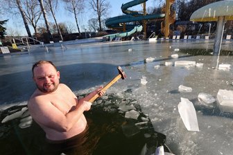 Verrückter Winterspaß im Plauener Freibad: Vogtländer gehen mitten im Januar baden - warum ein Vorschlaghammer dabei nicht fehlen darf - „Eisbrecher" Paul Groschinski holte im eiskalten Wasser mit dem Vorschlaghammer aus.