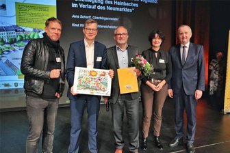 Verschollen und zugepflastert: „Ab in die Mitte“-Preisträger Auerbach will Bach öffnen - Staatsminister Thomas Schmidt und Laudatorin Mirjam Philipp (von rechts) gratulieren Auerbachs OB Jens Scharff (Mitte) und Amtsleiter Knut Kirsten (Zweiter von links).