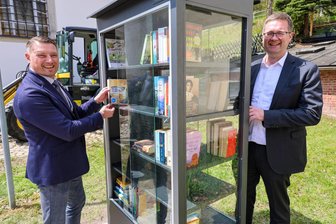 Verspätetes Geschenk von der Partnergemeinde: In Schönheide steht jetzt ein Bücherschrank - Schönheides Bürgermeister Thomas Lang (links) und Elmar Bociek, Bürgermeister der Partnergemeinde Sulzbach, haben den Bücherschrank bestückt.