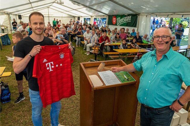 Versteigerung zum Dorffest: Thomas-Müller-Trikot bringt 130 Euro - Tobias Grimm ersteigerte am Samstag zum Dorffest in Schreiersgrün ein handsigniertes FC Bayern-Trikot von Thomas Müller. Auktionator Frank Petzold war zufrieden.