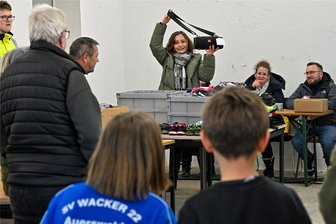 Versteigerungsfieber in Lichtenau: Zehnjähriger überbietet eigene Mutter - Spannung bei der öffentlichen Versteigerung in der Gemeinde Lichtenau: Rathaus-Praktikantin Josephin Schellenberger zeigt eine Musikbox. Das Anfangsgebot lag bei 25 Euro. Verkauft wurde sie für 64 Euro.