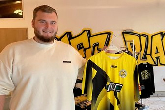 VFC Plauen: Was die Renner und die Geheimtipps im neuen Fanshop sind - Geschäftsführer Felix Koppe vom VFC Plauen hält einen der Renner des Fanshops in die Kamera: Das Heimtrikot.