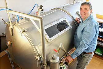 Vielauer Altar in Zwickau: Das sind die Retter von Peter Breuers Meisterwerk - Restaurator Karsten Püschner steht in seinem Hartmannsdorfer Atelier an einem extra gebauten Edelstahlbehälter, in dem der Vielauer Altar jahrelang entölt wurde. 