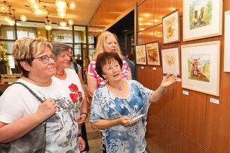 Viele Stile, viele Künstlerinnen und ein froher Galerist - Maria Ludwig schaut sich mit ihren Kursteilnehmerinnen die Ausstellung in der Kleinen Galerie an.