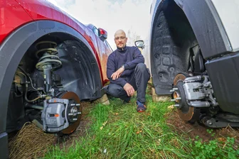 Vier Neuwagen stehen auf Pflastersteinen und Felgen: Mazda-Autohaus in Meerane war Ziel von Räder-Dieben - Mitarbeiter Patrick Schubert zwischen zwei Autos, an denen die Räder fehlen.