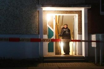 Vier Tote in Wohnung in Jena - wahrscheinlich Beziehungsdrama - Polizeibeamte stehen im Eingang eines Wohnhaus. Hier wurden vier Leichen gefunden.