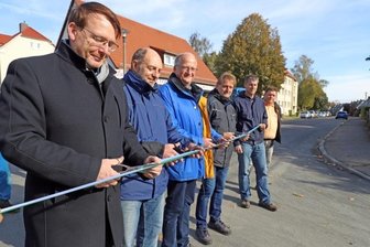 Vier Wochen eher freie Fahrt - OB Sven Krüger (links) setzte mit Bauverantwortlichen die Schere an. Ab sofort kann der Verkehr wieder über die Kreuzung Mühlweg/Straße der Einheit rollen.