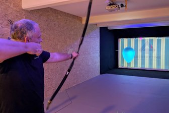 Virtuelle Jagd in Oederan: Schützen zielen auf animierte Hirsche - Kay Riedel spielt aktiv ArcheryTime.an der virtuellen Zielwand.