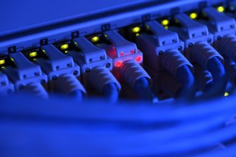 Vodafone schließt 20 Bauprojekte in Mittelsachsen ab und plant fünf weitere - Ein Netzwerk-Kabelstecker leuchtet in der Netzwerkzentrale einer Firma zu Kontrollzwecken rot.