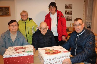 Vogtländer packen Geschenke für Kinder - Monika Lorenz, Ursula Scheurig, Günter Schneider und Oliver Lommatzsch (von links) mit zwei Paketen sowie Diakonie-Mitarbeiterin Bianca Däumler (stehend rechts).