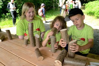 Vogtländische Kinder lernen in Eich den Wald mit allen Sinnen kennen - Mit Eigenschaften von Holz beschäftigen sich Doris Müller, Ludwig und Carlo (v. l.) von der Treuener Kita Märchenland in Eich.