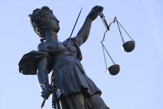 Eine Statue der Justitia steht unter freiem Himmel.