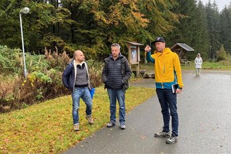 Vogtland wieder Drehort: MDR-Fernsehen bereitet neue Ausgabe von „Unterwegs in Sachsen“ vor - Wo soll MDR-Moderator Alex Huth auf Skirollern laufen? Tim Tröschel (rechts) bespricht mit Kameramann Tom Schneider und Aufnahmeleiter Frank Leichauer (links) den Dreh an der Rollerbahn in Grünbach.