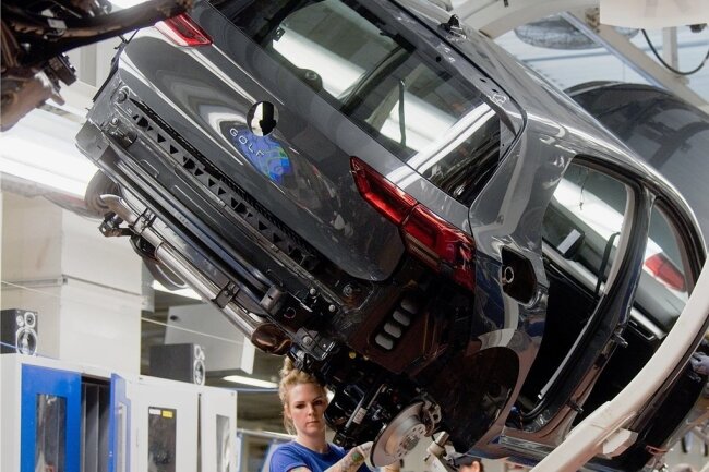 Volkswagen unterbricht wegen Coronarisiken die Produktion - Noch arbeiten Mitarbeiter an einem Volkswagen Golf 8 an einer Produktionslinie im VW Werk in Wolfsburg. 