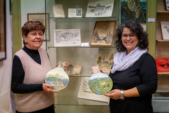 Volle Platte: Ort im Erzgebirge zeigt seine kreative Seite - Nadja Köhler (r.) und Monika Thierfelder beim Einräumen der Vitrinen für die neue Ausstellung.