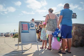 Volle Strände an Nord- und Ostsee - Badeorte raten von Anreise ab - Badegäste warten am Strandzugang in der Dorfschaft Haffkrug der Gemeinde Scharbeutz.