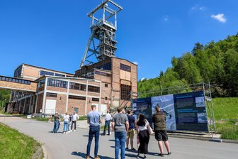 Volles Haus nach einer Viertelstunde: Wismut-Ausstellung im Erzgebirge bringt Besucher zum Strahlen - Ikonischer Ort. Schautafeln auf dem Anmarschweg zeigen, wie es auf dem Gelände des Schachts 371 früher aussah.