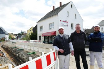 Vollsperrung vor der Haustür: Wie sich eine Fleischerei in Borstendorf über Wasser hält - Fleischermeister Felix Wagner, Geschäftsführer Silvio Freitag und Koch Martin Kister (v. l.) stehen an der Baustelle vor der Fleischerei Borstendorf.