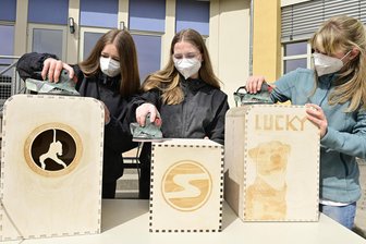 Vom digitalen Entwurf zum fertigen Instrument: Schüler aus dem Vogtland meistern besonderes Unterrichtsprojekt - Mia Müller, Svenja Schwarzenberger und Leonie Herold (von links) beim Schleifen ihrer Instrumente.