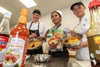 Vom Küchengespräch bis zur Flucht-Geschichte - Phillip Weißmann, Marut Schmidt und Elisa Kern (von links) bereiten bei der Interkulturellen Woche an der Burgstädter berufsbildenden Don Bosco-Schule beim thailändischen Kochkurs Frühlingsrollen zu.
