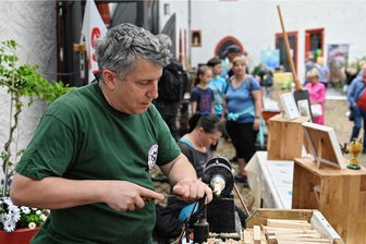 Vom Kunstmarkt auf der Rochsburg bis zum legendären Dorffest Lichtenberg: Fünf Tipps für Teil zwei des Himmelfahrt-Wochenendes in Mittelsachsen - Die Faszination von Handwerk und Kreativität steht am Sonntag auf Schloss Rochsburg wieder im Mittelpunkt. Im Jahr 2022 führte Uwe Kempe vom Bergbauverein Olbernhau eine Fuß- und Schwungrad-Drechselbank vor. 