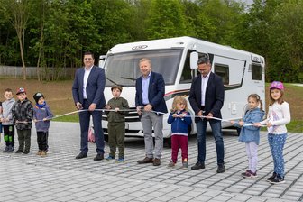 Vom Schandfleck zum Anziehungspunkt: Falkenstein weiht neuen Caravan-Stellplatz an der Talsperre ein - Einweihung des neuen Caravan-Stellplatzes in Falkenstein: Landrat Thomas Hennig, Bürgermeister Marco Siegemund und Landtagsabgeordneter Sören Voigt (alle CDU, v. l.) und Kinder aus der Kindertagesstätte Albert Schweitzer.
