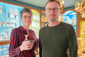 Vom Spreewald nach Seiffen: Worüber sich Kahnfahrer und Spielzeugmacher austauschen - Kahnfährfrau made in Seiffen: Dregeno-Geschäftsführerin Juliane Kröner überreicht Steffen Franke, Vorstandsvorsitzender der Kahnfährgenossenschaft Lübbenau, eine Holzminiatur.