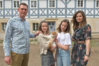 Vom Zweifel zur Bewunderung: Wie ein verfallenes Haus in Kleinschirma zu neuem Leben erwachte - Familie Philipp und Pia Wittenburg mit ihren Töchtern Hanna, Anni (v. l.) und Kater Benny vor ihrem liebevoll sanierten Haus in Kleinschirma.