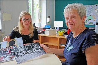 Von Bergparade bis Mini-Puhdys: Was die "Bergstadtzwerge" Freiberg in sechs Jahrzehnten erlebten. - Angela Arnold (r.) und Kita-Leiterin Katja Kranz schauen sich alte Fotos aus der Geschichte der "Bergstadtzwerge" an.