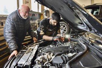 Von der Wartburg-Vertragswerkstatt in die Zukunft: Wie ein afghanischer Flüchtling den Autopark Limbach künftig leiten wird - Uwe Kosalla blickt Amin Ali Sofi beim Abdichten eines Turboladers über die Schulter.