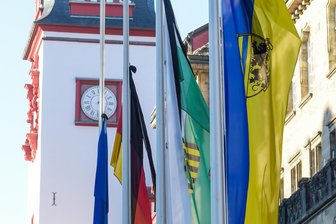 Von „Gemeinschaftssinn stärken“ bis „widerliche Diskussion“: Debatte um dauerhafte Beflaggung in Chemnitz - Die Flaggen von Chemnitz, Sachsen, Deutschland und der EU (von rechts) an den Masten vor dem Rathaus. Sie werden zu besonderen Anlässen gehisst oder auf Halbmast gesetzt.
